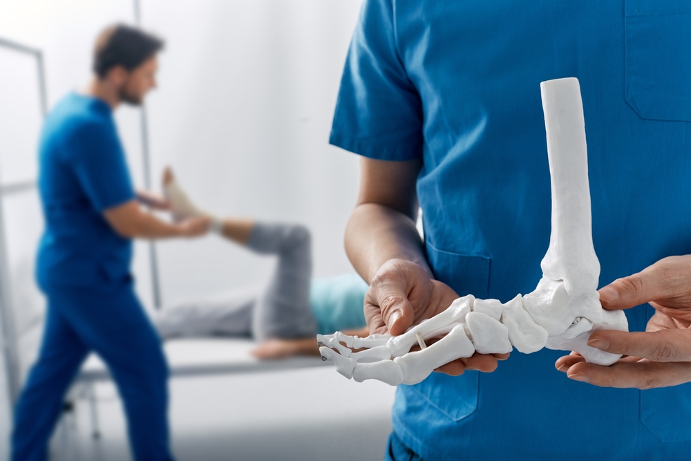 Podiatrist,Showing,Anatomical,Foot,Skeleton,Model,During,His,Assistant,Examination